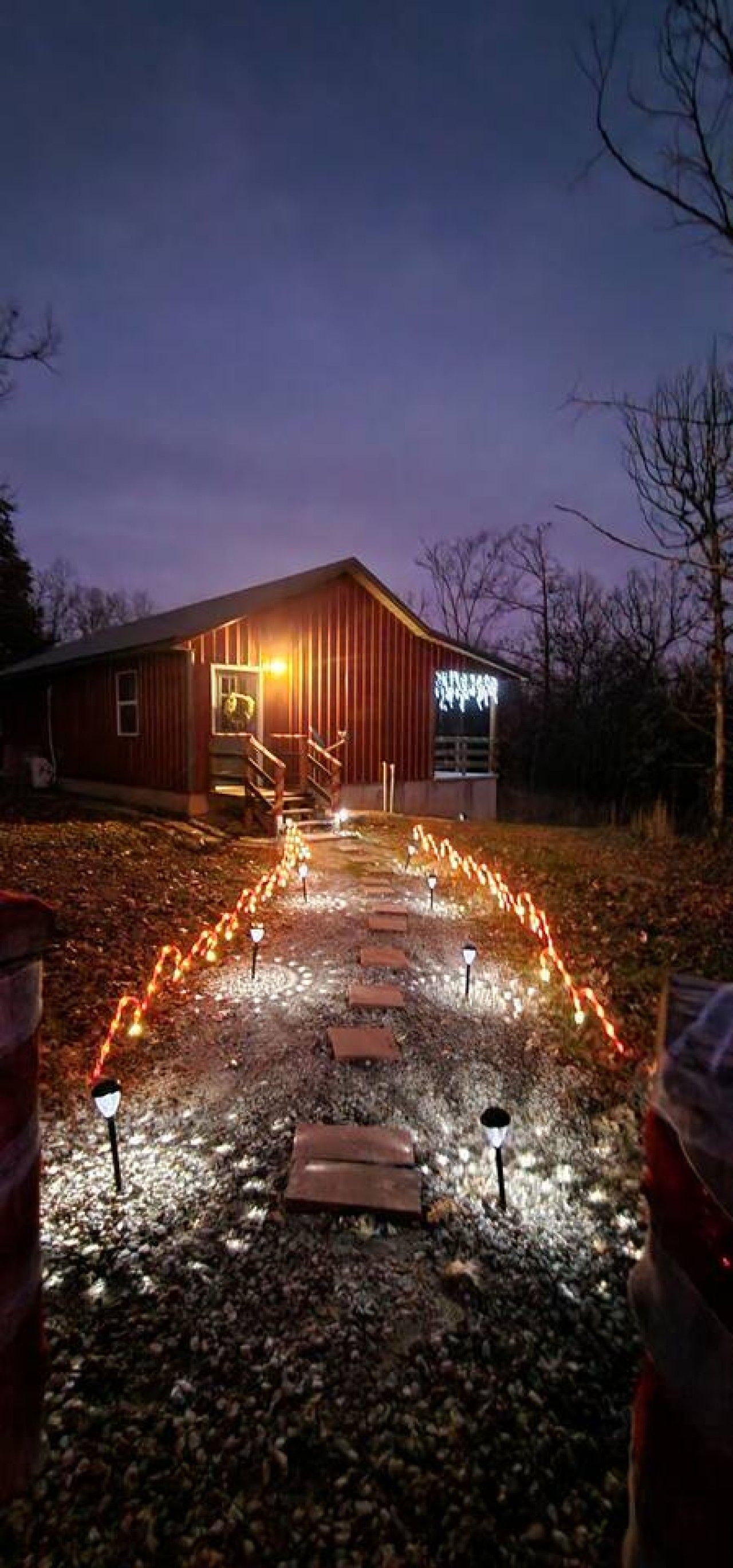 A building with a wooden exterior and a paved pathway leading to it.
