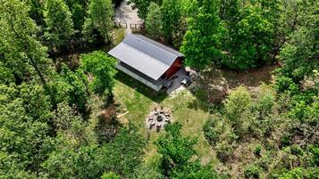 A single-story building with a flat roof, surrounded by dense green forest.