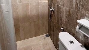 A shower with a handheld showerhead, a wall-mounted faucet, and a toilet with a bidet attachment. - Colletion O near Living Plaza Cirebon fo (West Cirebon)