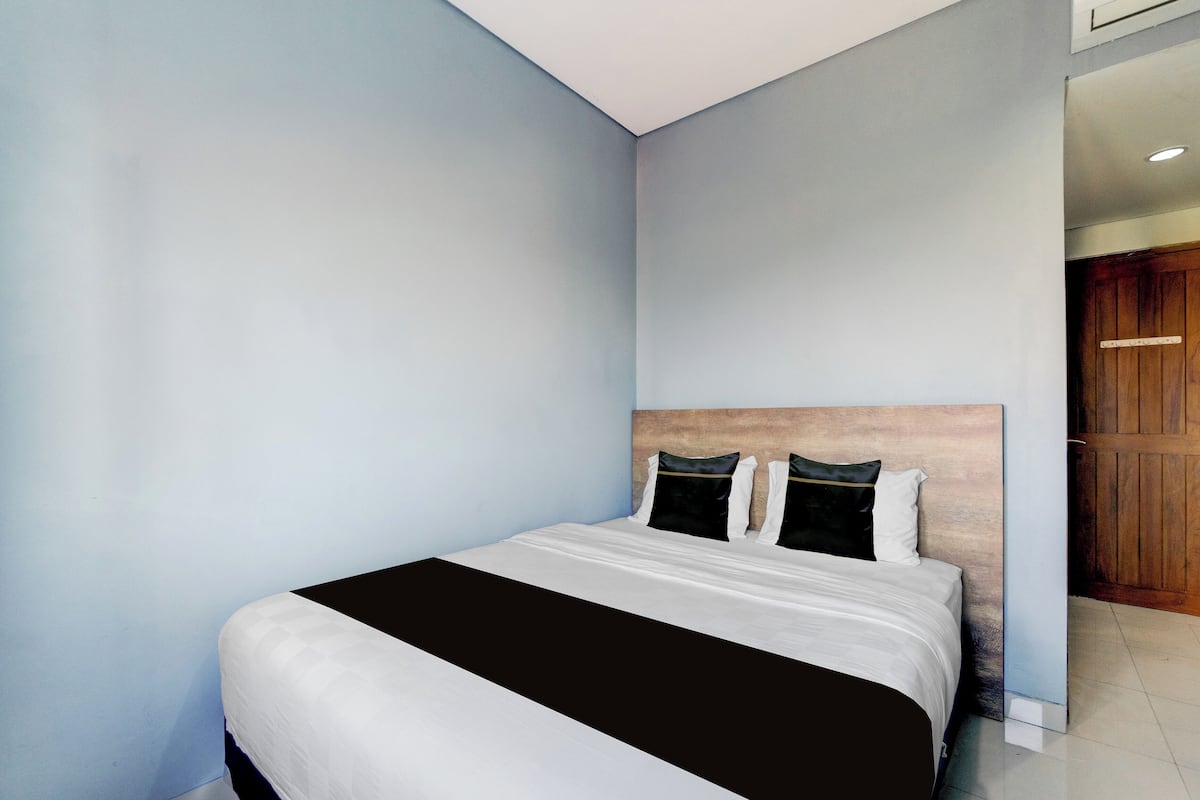 Ein Schlafzimmer mit einem Bett, hellblauen Wänden und einem hölzernen Kopfteil.
