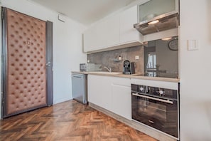 A modern kitchen with a dishwasher, oven, and a large window. - Champs de Mars - Chic 4-bedroom T5, fully equipped (Toulon)