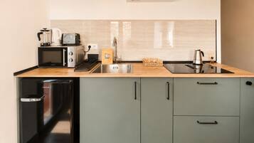 A compact kitchen with a microwave, toaster, sink, and a dishwasher.