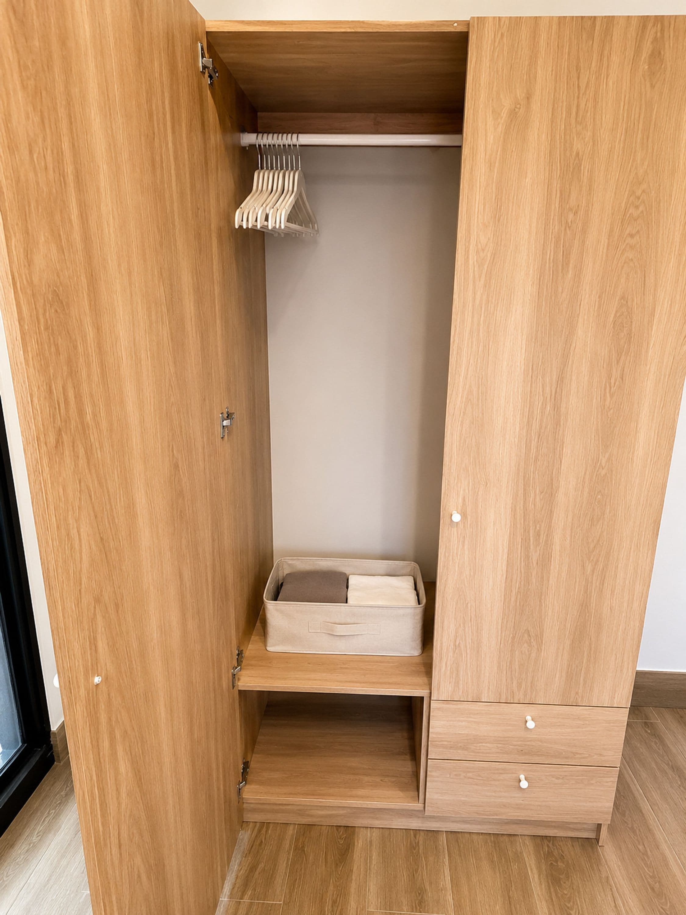 Un armario de madera con espacio para colgar y un estante inferior.