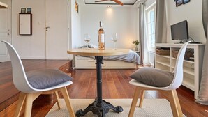 A room with a round table, two chairs, a wine bottle, and glasses. - Dream stay at Tamaris - Studio with sea view (La Seyne-sur-Mer)