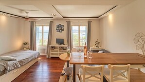 A bedroom with a bed, a desk, a dining table, and a view of the outdoors. - Dream stay at Tamaris - Studio with sea view (La Seyne-sur-Mer)