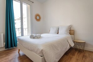 A bedroom with a bed, a round mirror, a small round table, and a window with curtains. - Le Refuge Urbain - Port 2 steps away & pets welcome (Toulon)