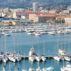A marina with numerous boats docked, surrounded by buildings with red-tiled roofs. - Stopover in Toulon • Cosy, quiet & conveniently located (Toulon)