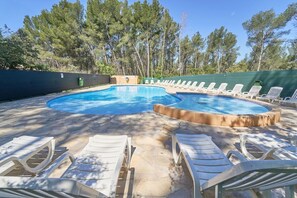 A swimming pool with lounge chairs, surrounded by trees. - Évasion aux Cystes - Swimming pool & terrace (Sanary-sur-Mer)