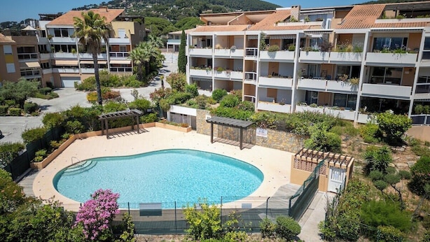 A residential building with a swimming pool, balconies with plants, and a garden area. - Le Corsaire : Relaxing Stay, Beach & Pool (Carqueiranne)