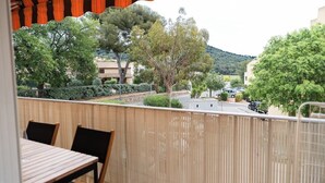 A balcony with a view of a street, trees, and buildings. - Le Corsaire : Relaxing Stay, Beach & Pool (Carqueiranne)