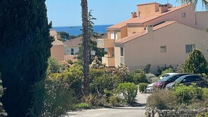 A residential area with a tall palm tree, a row of houses with red-tiled roofs, and a clear blue sky. - Le Corsaire : Relaxing Stay, Beach & Pool (Carqueiranne)