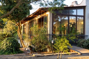 A building with large windows, a covered porch, and a garden with various plants. - Appartamento Lucentia Rosso - Va... (Valderice)
