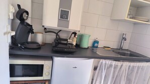 A compact kitchen with a microwave, a small refrigerator, a kettle, and a sink. - Studio Horizon Toulon - near port & arsenal (Toulon)
