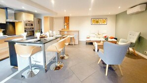 Una cucina moderna con angolo bar, sedie da pranzo, un divano e un tavolino da caffè.