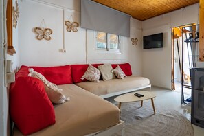 Ein modernes Wohnzimmer mit einer Eckcouch, einem Flachbildfernseher und einer Holzboden.