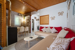 Ein modernes Wohnzimmer mit einer Couch, einem Couchtisch und einem Essbereich mit Stühlen.