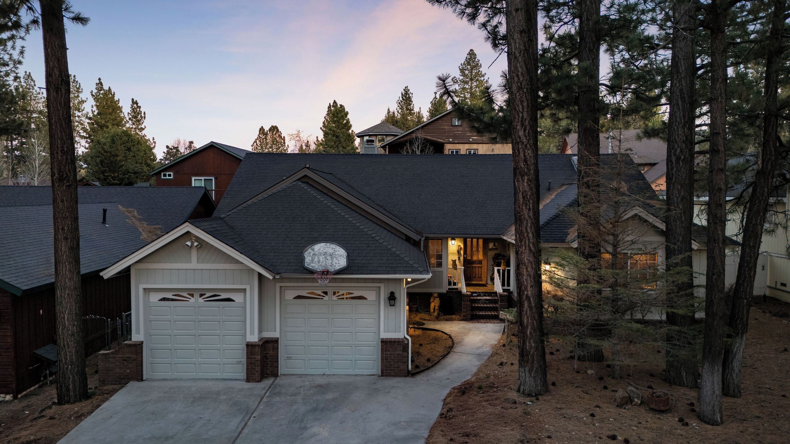 A residential house with two garage doors, a front porch, and a driveway.