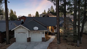 A residential house with two garage doors, a front porch, and a driveway.