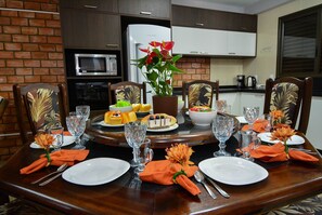 A dining table set with plates, cutlery, and a centerpiece.