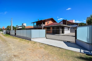A residential area with houses, a gated entrance, and a clear sky.