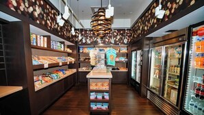 En butik med hylder fyldt med snacks, en midterplads og et køleområde til højre.