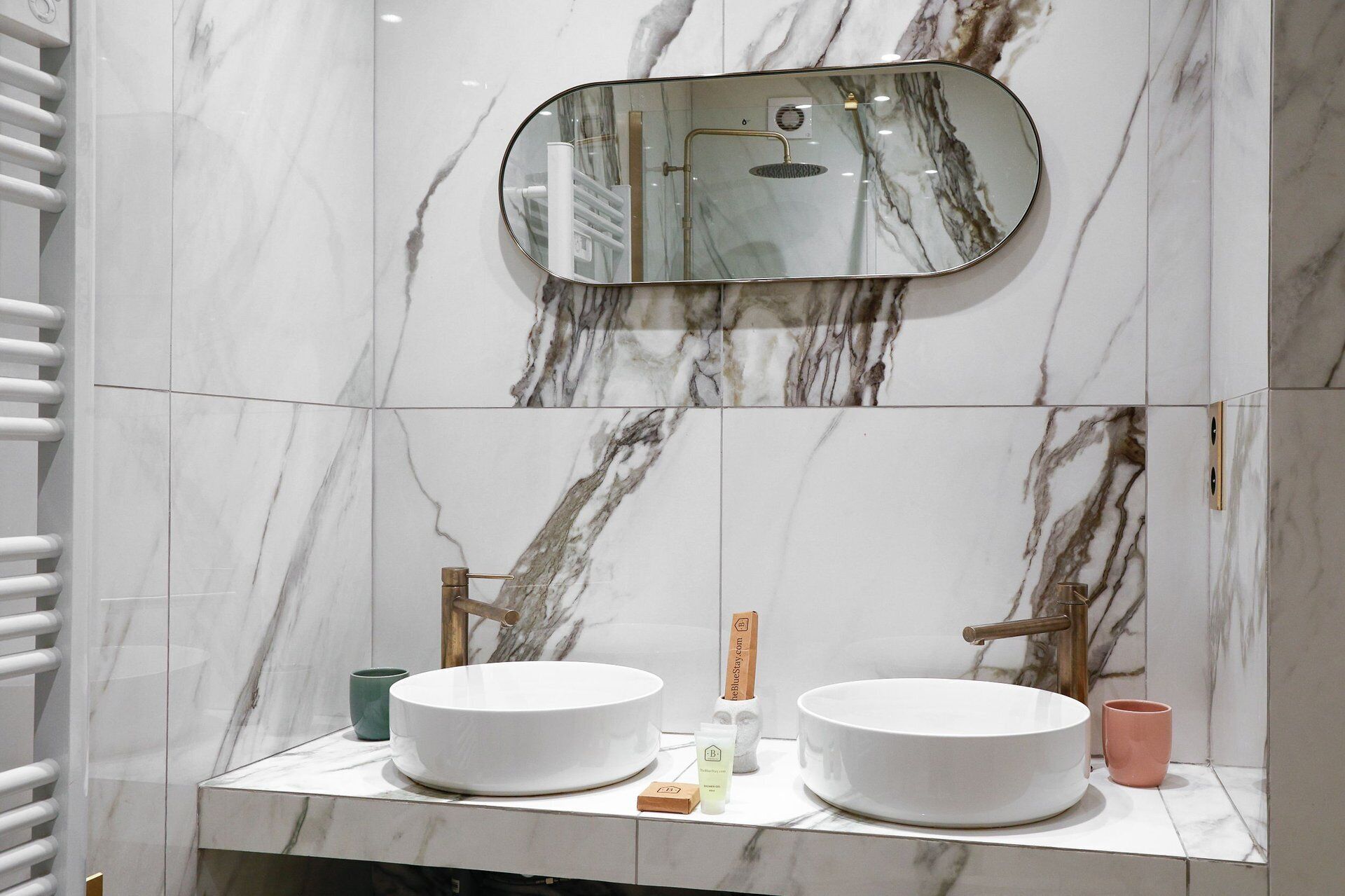 Une salle de bain avec deux lavabos, un miroir et une douche.