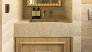A bathroom with a mirror, sink, and wooden cabinets. - Modern Apartment a/c 1ch/4p - Saint -germain (Paris)