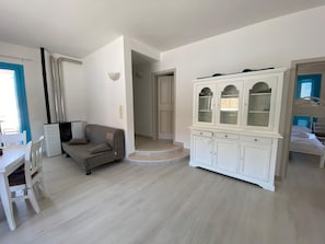 Un salon comprenant un canapé, une table à manger et un buffet.