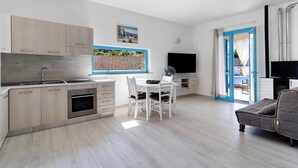 Una cocina moderna con comedor, televisor y sofá.