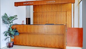 A reception desk with 'RECEPTION' and 'CASHIER' signs, a potted plant, and a wooden counter. - Luxury Deluxe DBL Retreat W/ Free WiFi and Parking (Bandung)