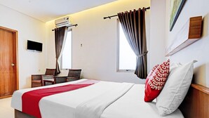 A hotel room with a bed, a TV, a desk, and two windows with curtains. - Luxury Deluxe DBL Retreat W/ Free WiFi and Parking (Bandung)