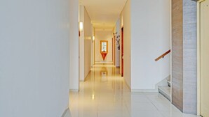 A modern hotel hallway with a polished floor, a staircase, and a door with a wooden handrail. - Luxury Deluxe DBL Retreat W/ Free WiFi and Parking (Bandung)