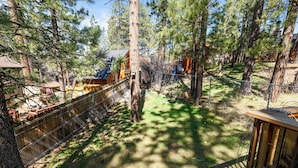Un espace extérieur clos, agrémenté d’arbres et doté d’une structure en bois.
