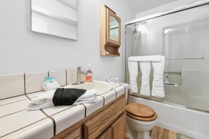 A modern bathroom with a wooden vanity, a sink, a mirror, and a glass-enclosed shower. - Teacher's Dream (Big Bear Lake)