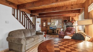 Un intérieur en bois avec un canapé, une table ronde en bois et une cheminée.