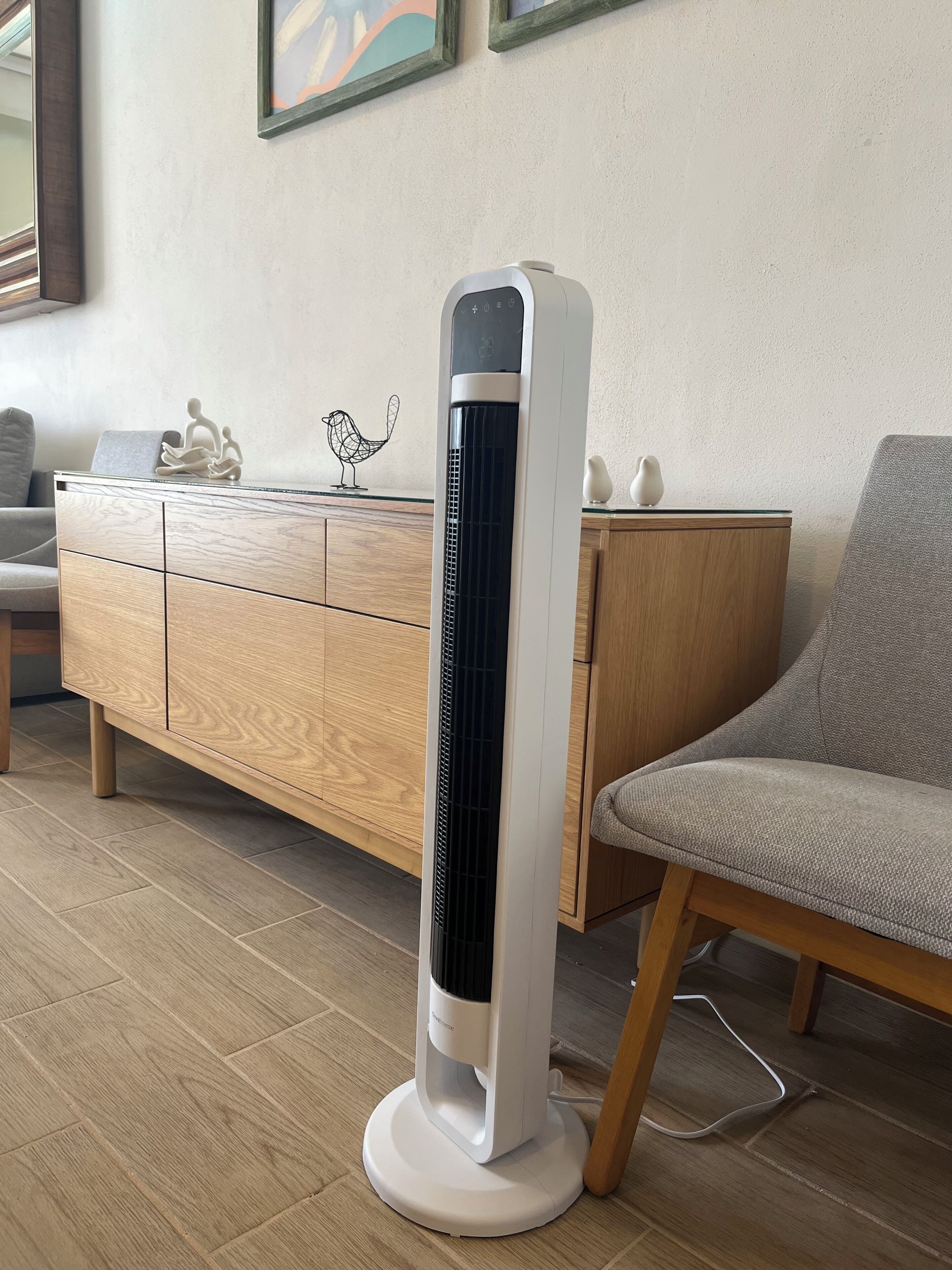 A modern room with a standing heater, wooden furniture, and a chair.