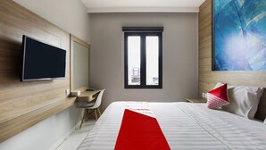 A modern hotel room with a large bed, a desk, a flat-screen TV, and a window with a city view. - Luxury Deluxe DBL Escape W/ Free WiFi and Parking (Bekasi)