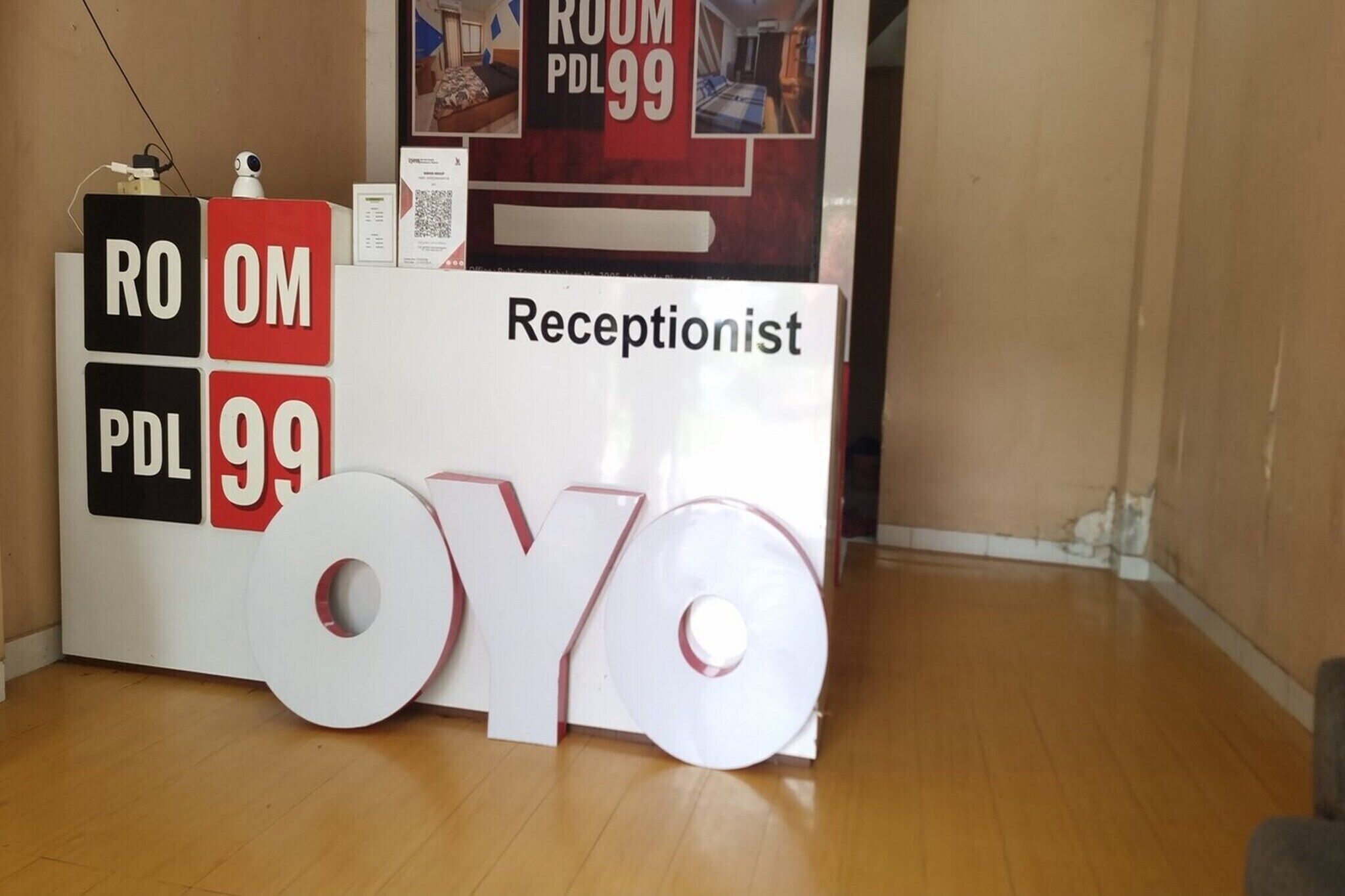 A reception desk with a sign indicating 'Receptionist' and 'ROOM PDL 99'.
