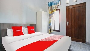 A hotel room with a bed, a wardrobe, a door, and a window with curtains. - Cozy Double Escape W/ Free WiFi and Parking (Bandar Lampung)