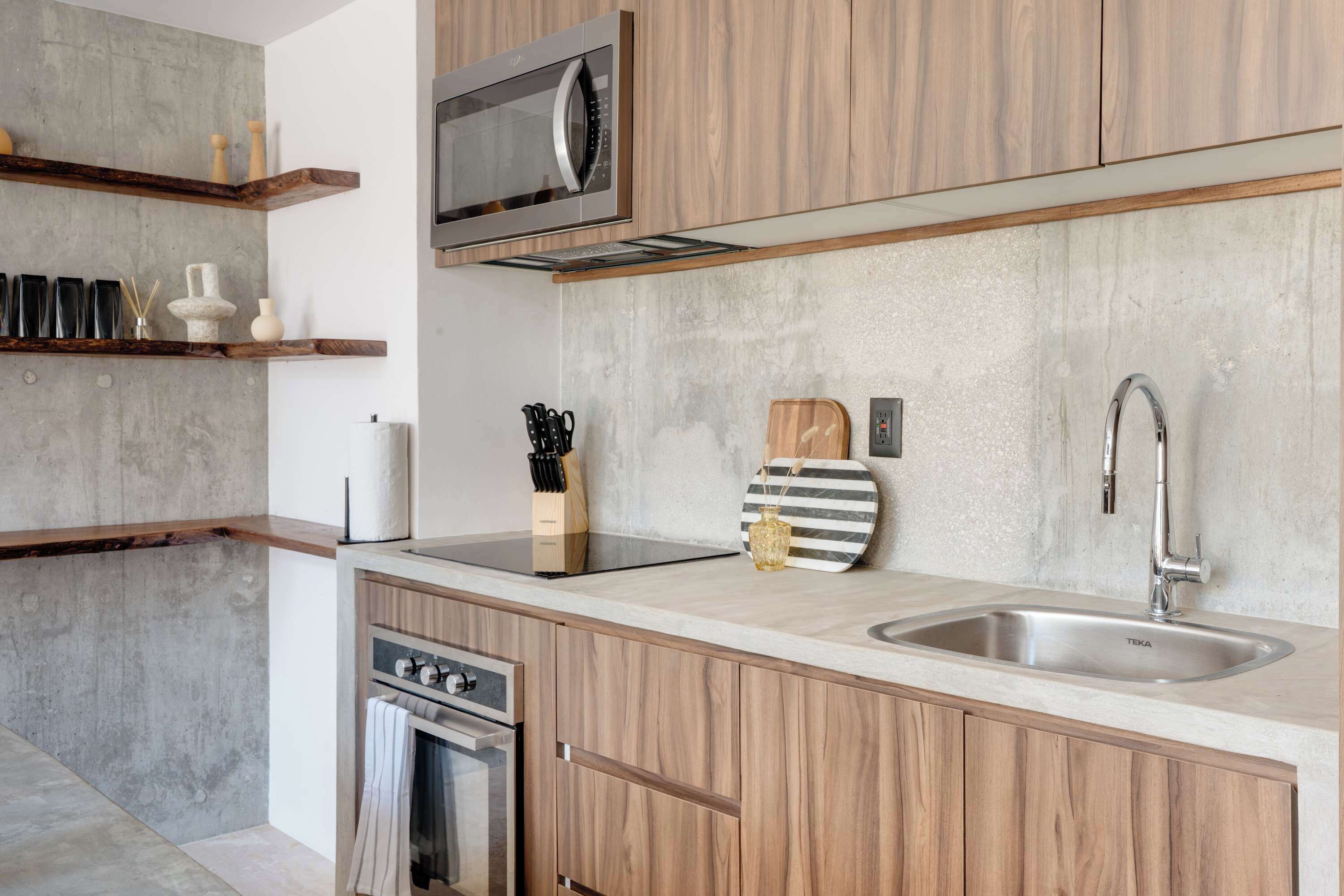 A modern kitchen with wooden cabinets, a stainless steel sink, and a built-in microwave.
