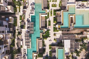 An aerial view of a resort with multiple swimming pools, outdoor seating areas, and lush landscaping. - Luxury 2BR Retreat with Private Pool & Spa (Tulum)
