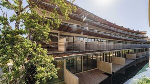 Een modern hotel met meerdere balkons, een zwembad en een terras.