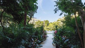 A pathway flanked by lush greenery leading to a building with multiple balconies. - Luxury Two-Level Loft in Tulum with Pool & Gym (Tulum)