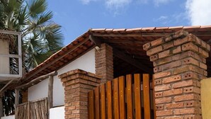 A brick house with a wooden gate and a wooden deck. - Urra Village Pousada Atins (Atins)