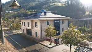 Een gebouw met twee verdiepingen, een plat dak, grote ramen en een balkon.