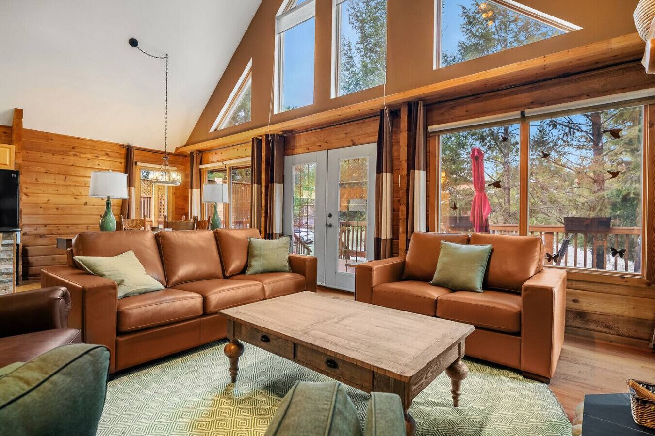 Main floor living room with a wood-burning fireplace, board games, cozy seating options and walkout access to the deck.