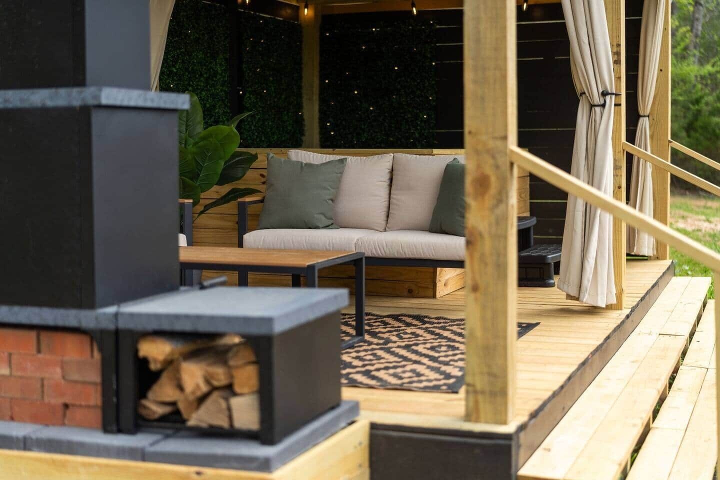 Une terrasse en bois avec un canapé et une cheminée.