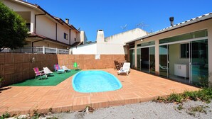 A backyard with a swimming pool, wooden deck, and outdoor furniture. - Casa com Piscina a 250m da Praia PLH006 (Palhoça)