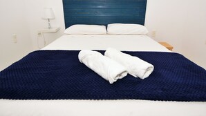 A bed with a blue headboard, white pillows, and a dark blue blanket. - Casa com Piscina a 250m da Praia PLH006 (Palhoça)