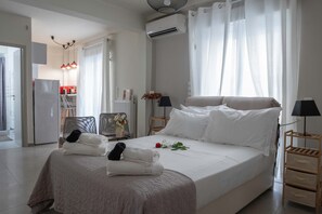 Ein modernes Hotelzimmer mit einem großen Bett, einem Schreibtisch und einer Küchenzeile.